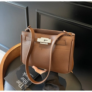 Detail of brown litchi grain leather bag showing the silver twist lock and texture