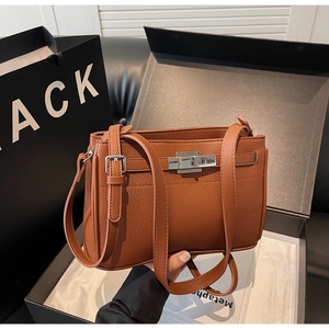 Close-up of brown lychee grain leather crossbody bag with silver metal swivel lock