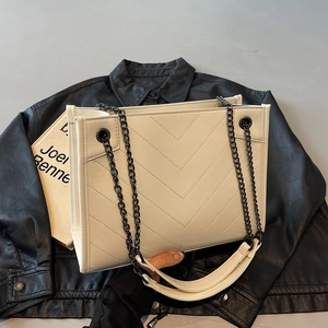 White quilted tote bag with V-shaped stitching and black nickel chain straps for commuting