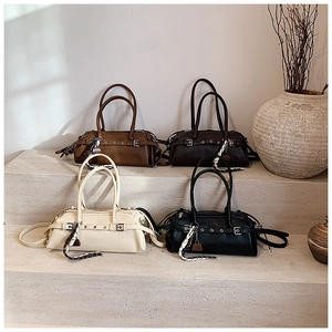 Detailed view of four Boston-style handbags with leather belts and silk scarf charms