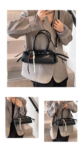 Detail of black faux leather baguette bag featuring side straps and metallic eyelets