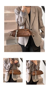 Detail of brown barrel bag with silver buckle and striped silk scarf accessory