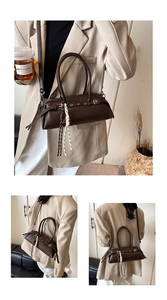 Detail of dark brown baguette bag with leather straps and decorative woven rope charm
