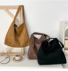 Detailed view of suede tote bags in caramel, dark brown, and black colors