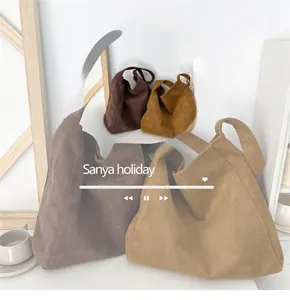 Macro detail of high-capacity suede tote bags in earthy tones with soft matte texture