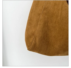 Close-up of brown suede fabric texture and professional stitching on canvas crossbody bag