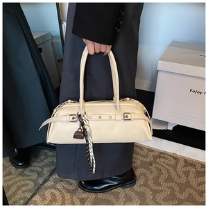 Detail of off-white leather Boston bag with decorative buckle and striped pendant charm