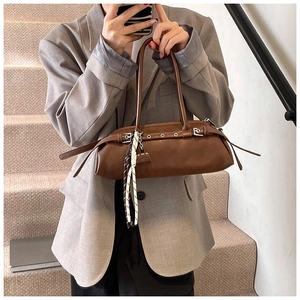 Detail showing vintage brown baguette bag with metal buckle strap and silk scarf accent