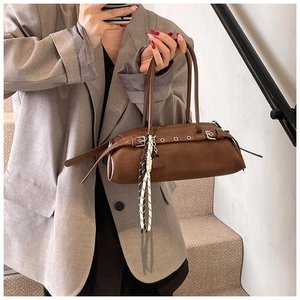 Detail view of dark brown leather baguette bag with a decorative striped scarf on the handle