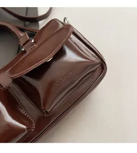 Detail of the CLEAROK logo embossed on glossy dark brown faux leather bowling bag