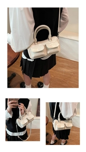 Detail of cream Boston bag with glossy oil wax leather and dual front flap pockets