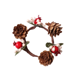 Rustic Christmas napkin ring with pine cones and red berries on a woody branch base