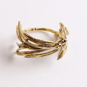 Macro detail of antique gold olive leaf napkin ring with vintage metallic texture