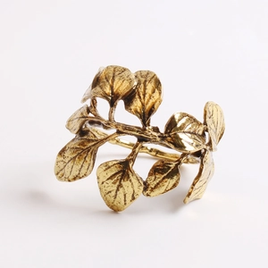Detailed view of olive branch napkin ring with realistic leaf texture in antique gold