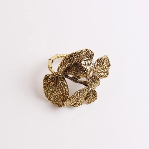 Detailed close-up of golden olive leaf napkin ring with intricate vein texture on metal
