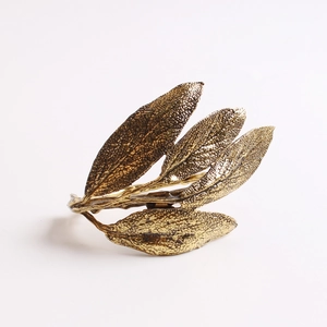 Detailed macro view of vintage gold leaf napkin ring with intricate leaf vein texture