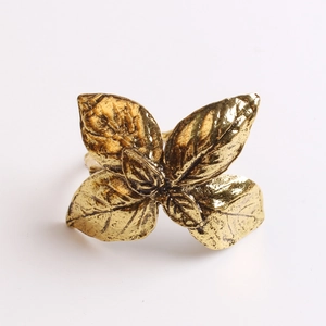Macro shot of gold olive leaf napkin ring showing vintage metal textures and veins