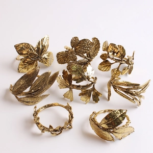 Close-up of golden olive leaf napkin rings with detailed vintage metal textures