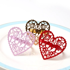 Detail of heart-shaped hollow LOVE metal napkin rings in pink, gold and red set