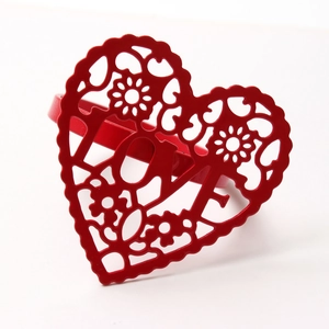 Detailed macro shot of a red heart-shaped metal napkin ring with LOVE cutout design