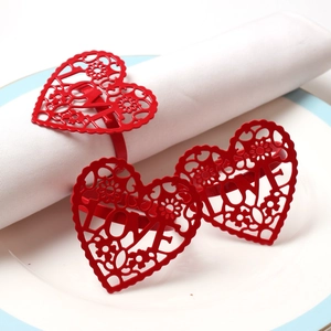 Close-up of red metal heart napkin rings with LOVE letters on white dinner plate