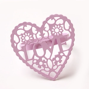 Close-up of pink heart napkin ring with LOVE cut-out design and floral pattern details