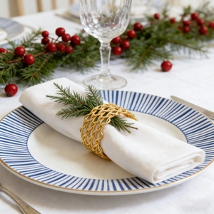 Elegant gold woven metal napkin ring on festive table setting with white linen cloth