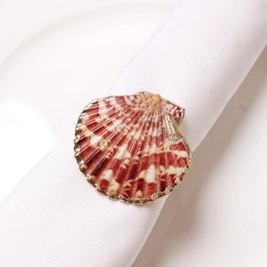 Macro shot of seashell napkin ring with gold rim and red-brown fan shell texture