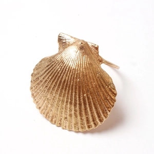Detailed view of the gold-colored shell texture and ribbed design on the napkin ring