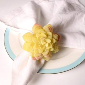 Minimalist yellow succulent flower napkin ring on white linen for elegant table setting