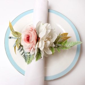 Elegant napkin ring with pink rose and white peony blossoms on a white plate