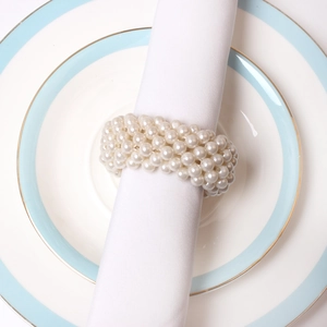 Elegant multi-layer white pearl beaded napkin ring on blue and white ceramic plate