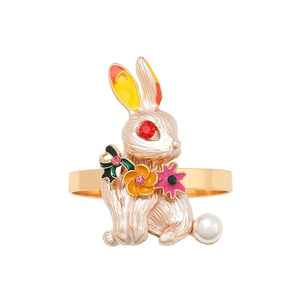 Golden rabbit napkin ring with white enamel, carrot colors, and pearl detail for table decor