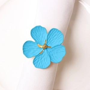 Light blue plum blossom napkin ring with golden stamen on white fabric napkin