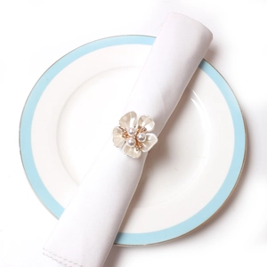 Detailed view of the elegant pearl rose napkin ring with gold petals and crystal core