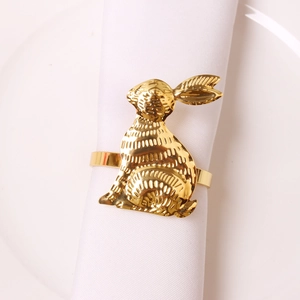 Rond de serviette lapin doré sur serviette blanche et assiette pour décor festif