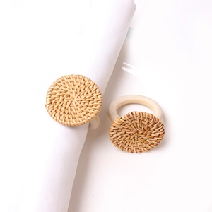 Close-up of hand-woven rattan napkin ring with sunflower design on white cloth