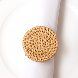 Detailed top view of a handmade round rattan napkin ring on a white ceramic plate