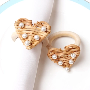 Handwoven heart-shaped rattan napkin rings with pearl accents and wooden loop holder