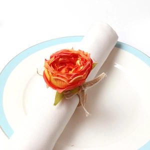 Close-up of orange fabric rose napkin ring with vintage rustic jute rope texture