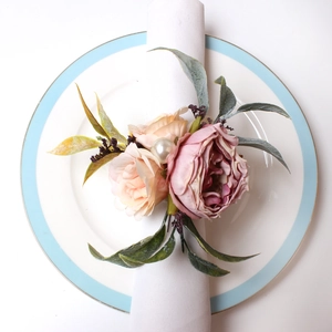 Detailansicht eines handgefertigten Serviettenrings mit rosa Rosen und Perlen