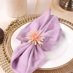Close-up of champagne floral napkin ring with pink lily flower petals and woven loop