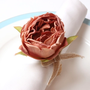 Macro detail of artificial peony napkin ring with natural jute rope and burlap bow