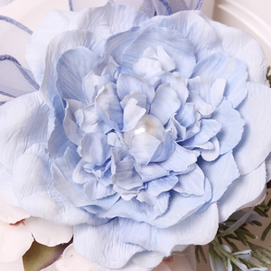 Detailaufnahme eines hellblauen künstlichen Rosen-Serviettenrings mit Perle und Organza