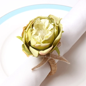 Macro detail of artificial green rose napkin ring with rustic woven rope and bow