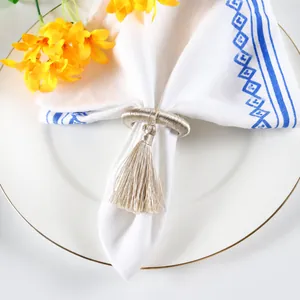 Detailed close-up of champagne gold fringed napkin ring with elegant spiral texture