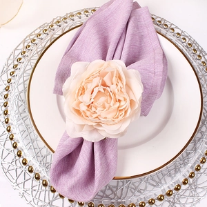 Pink peony napkin ring with purple linen napkin on a white gold-rimmed plate