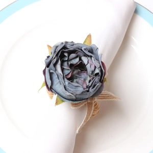 Macro shot of a vintage blue-grey artificial rose napkin ring with natural grass weave