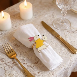 Vintage metal Easter bunny napkin ring on white lace cloth with candles