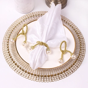 Golden woven bow napkin ring with pearls on a white plate, set of 3 for table decor
